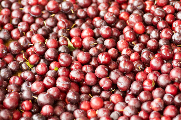 Fresh ripe red plums as a background