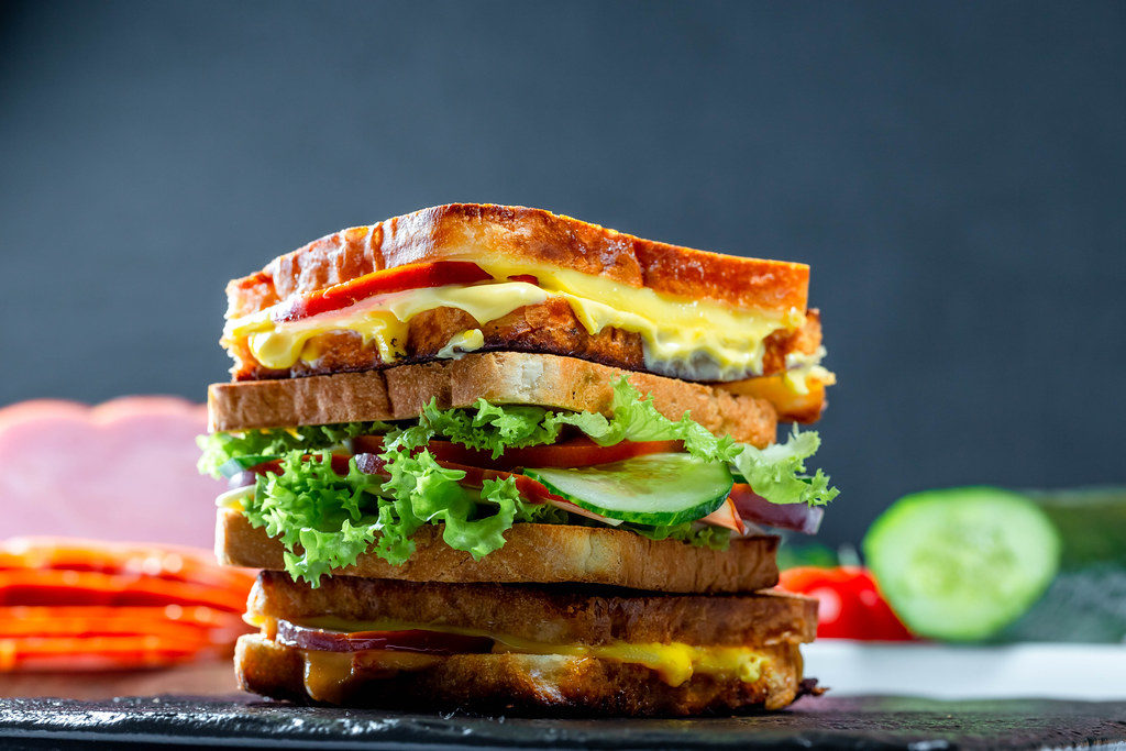 Layered sandwich with vegetables, ham and cheese